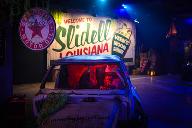 Skeleton driving a car in front of a sign that says Slidell, Louisiana