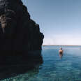 a woman in water between two boulders 