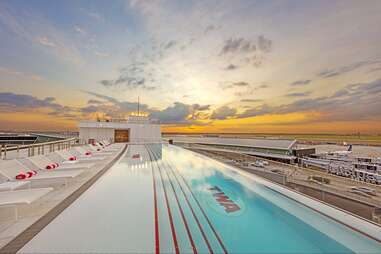 a rooftop pool at sunset with planes in the background