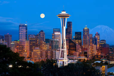 Downtown Seattle skyline and Space Needle at night with full moon.
