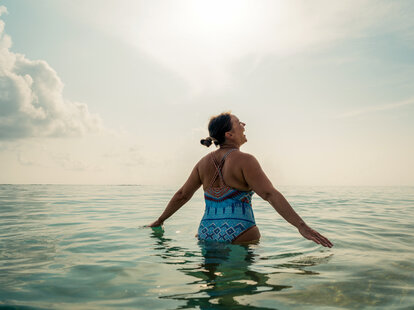 Woman standing in the ocean.
