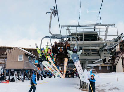 a mammoth, skiers, and snowboarders on a chairlift at mammoth mountain for opening day