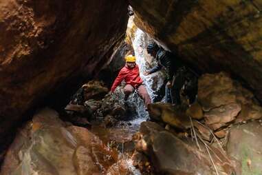 person canyoneering near a waterfall in australia