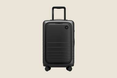 A small black carry-on suitcase from Monos with front pocket