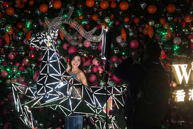 A photographer is taking pictures of a model near the Winterfest Christmas tree in Hong Kong, China,