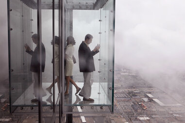 Visitors check out the view from the Ledge, a new glass cube that juts out from the 103rd floor Skydeck of the Sears Tower, during a media preview July 1, 2009 in Chicago, Illinois.