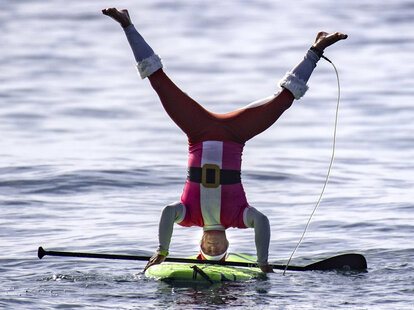 upside down santa on a stand-up paddleboard at dana point, california