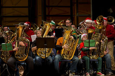 tubachristmas performance includes people playing brass instruments while dressed in christmas outfits