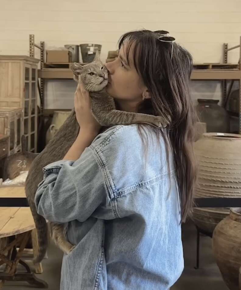 woman kissing cat