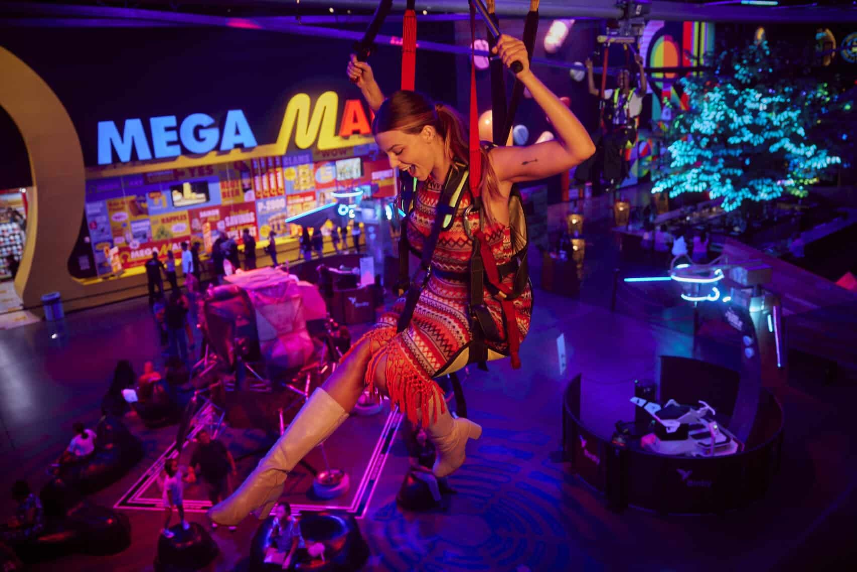 woman swings on a glider inside area15 in las vegas