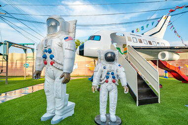 astronaut suits in front of a space shuttle slide as part of a backyard playground at a themed home near disneyland