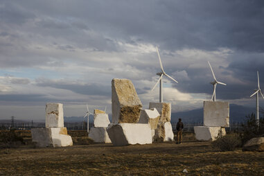 stone art in front of windmills for desert x in the coachella valley