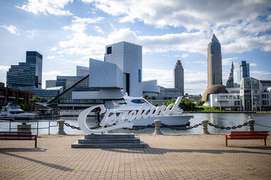 a statue that says cleveland in front of a boat on the waterfront in cleveland, ohio