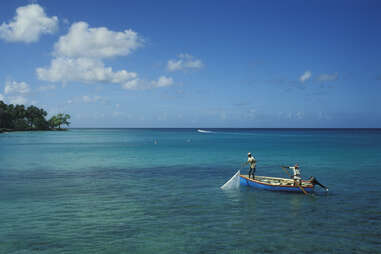 Two men fish in tranquil waters off the shore of