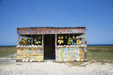 A fruit stand and beer shack selling locally grown produce and Red Stripe beers.