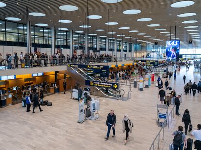 People walking through a large airport terminal