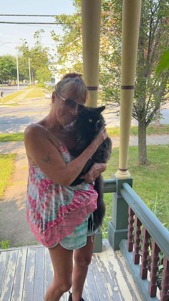 Two identical black cats sitting together