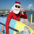 A surfer dressed as Santa.