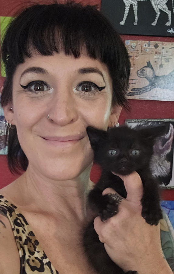 woman holding black kitten