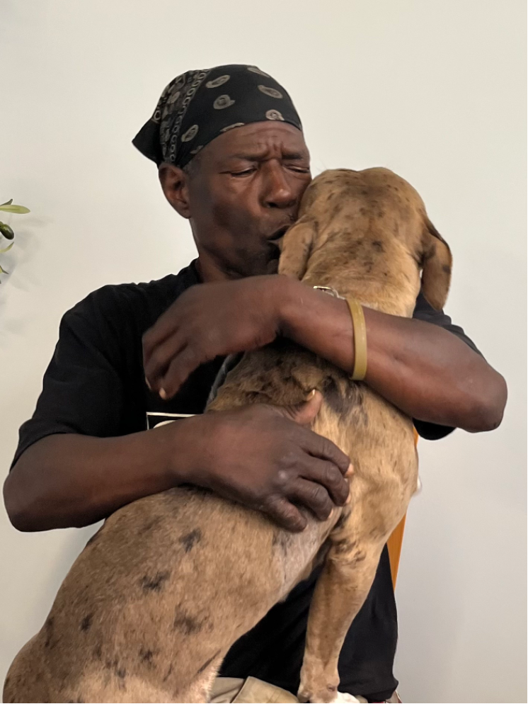 Man kisses his dog lovingly