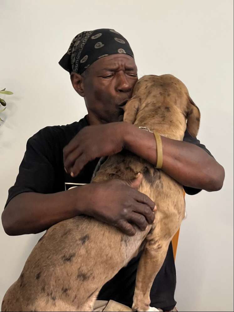 Man kisses his dog lovingly