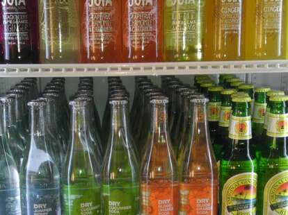 A shelf filled with colorful soda bottles.