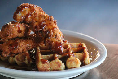 Boneless fried chicken breast smothered in BBQ syrup served over cornbread waffles at Cedar Point Bar & Kitchen