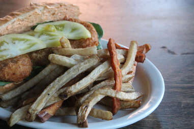 A pickled and fried green tomato po boy with sweet potato fries at Cedar Point Bar & Kitchen