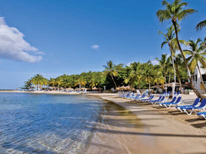 Lounge-chair laden beach in front of resort