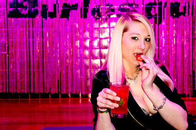 A bartender at Ivan Kane's Royal Jelly eats a strawberry on the stage of the Revel burlesque club