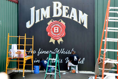 Painters finishing a Jim Beam sign on the stillhouse exterior