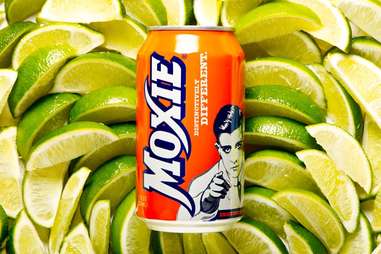 Can of Moxie soda on a bed of limes