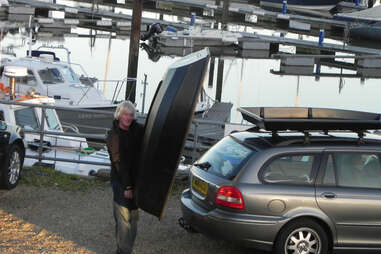 Boatpack being unloaded from the top of a car