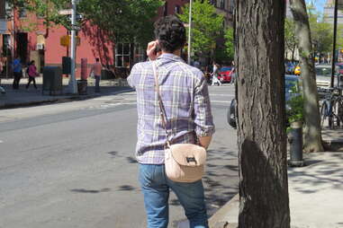 Man holding girlfriend's purse in Brooklyn