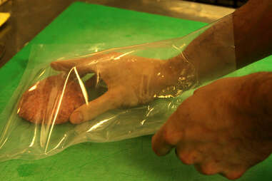A burger is placed in an airtight bag before being cooked sous-vide.