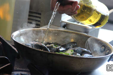 wine going in a pan full of mussels