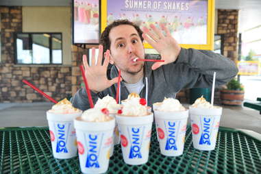 guy eats an oreo cheesecake milkshake at Sonic