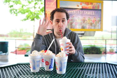 guy eats a pineapple milkshake at Sonic