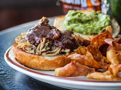 Pulled Pork Carnitas Sandwich with in house made mustard bbq sauce and guacamole.