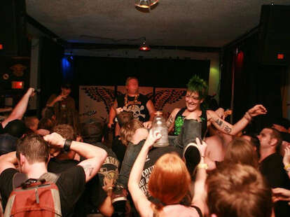 band on stage, crowd, woman crowd-surfing