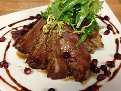Seared duck, greens, and pomegranate seeds 