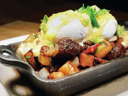 An eggs Benedict piled with potatoes and sour cream.