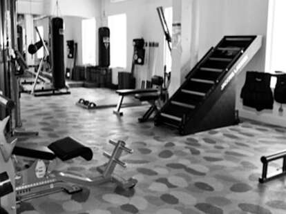 The interior of the gym with lots of weights and machines.