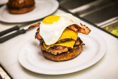 Chef tops off the 'Merica Burger with a fried egg at Slater's 50/50 in San Diego.