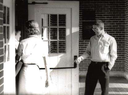 A gentleman with manners opening a door for a lady