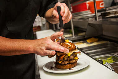 Chef places the final touch in the 'Merica Burger at Slater's 50/50 in San Diego.