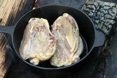 halved chicken in cast-iron pan
