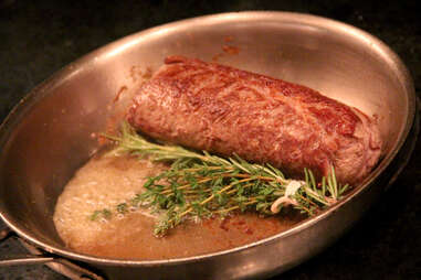 A lamb ribeye cooks in the frying pan at The Lambs Club