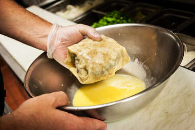 The tortilla is folded up and dipped in an egg wash before its deep fried.