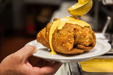 The Supreme Nacho Burger gets covered in nacho cheese at Slaters 50/50 in Liberty Station San Diego.